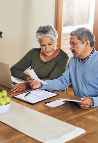 Finance, laptop and senior couple with bills, paperwork and receipt documents for life insurance. Retirement, fintech and elderly man and woman on computer for mortgage payment, investment and budget