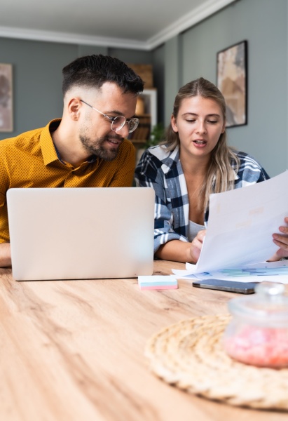Two young people, couple in relationship, working together at home office