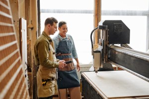 Woodworking employees using large machinery.