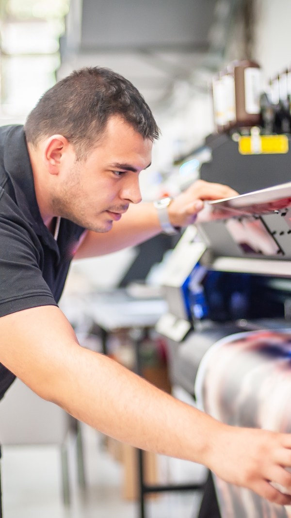 Man using printing machinery.