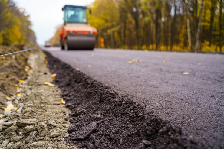 Machine laying asphalt for highway repair.