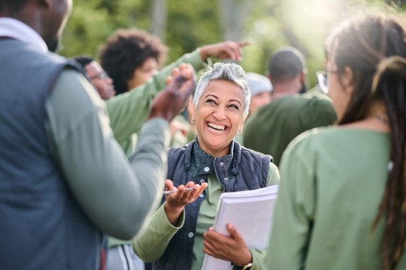 Senior woman volunteering with group outdoors