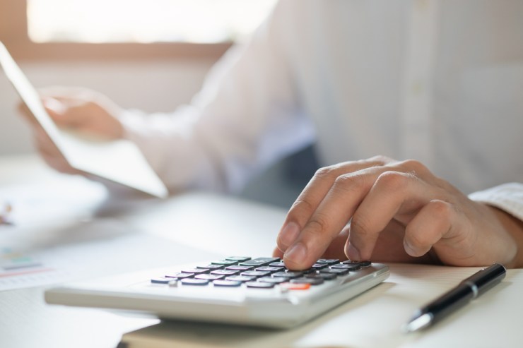 Close up of man using calculator.