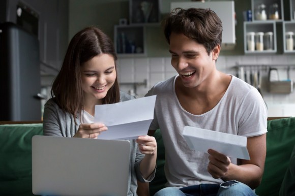 Happy young couple excited by reading mail.