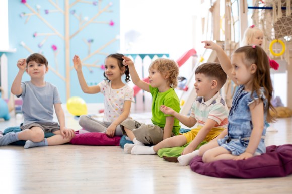 Children sitting in a half-circle at a daycare.