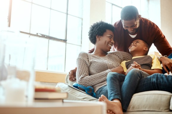 Young family of three sitting on the couch.