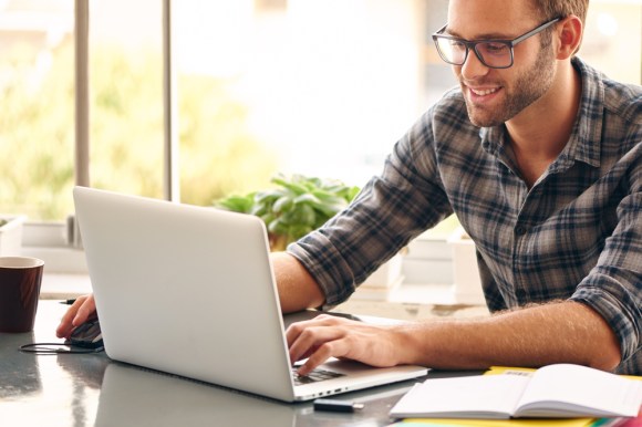 Young white man working on a laptop.