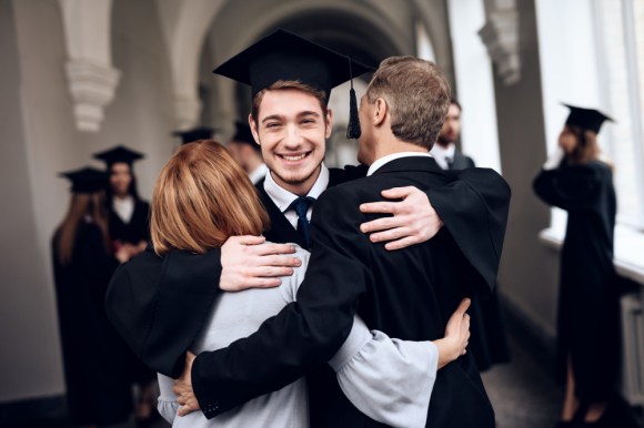 Caucasian college graduate with parents.