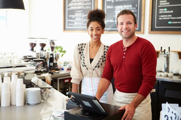 Male And Female Staff In Coffee Shop.