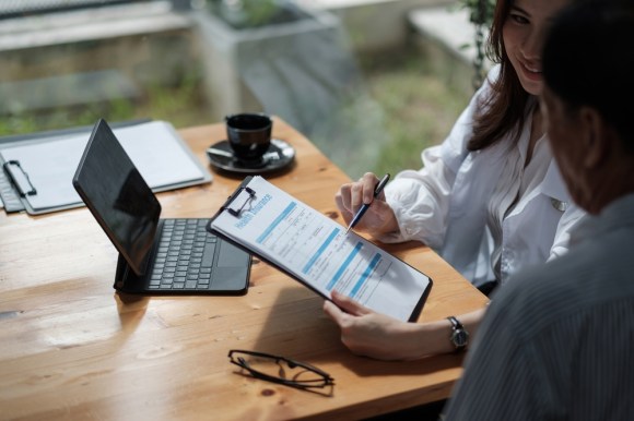 Two people reviewing a health insurance policy.