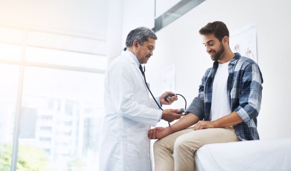 Man at the doctor’s getting his blood pressure checked.