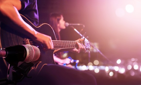 Guitarist and singer performing on stage.