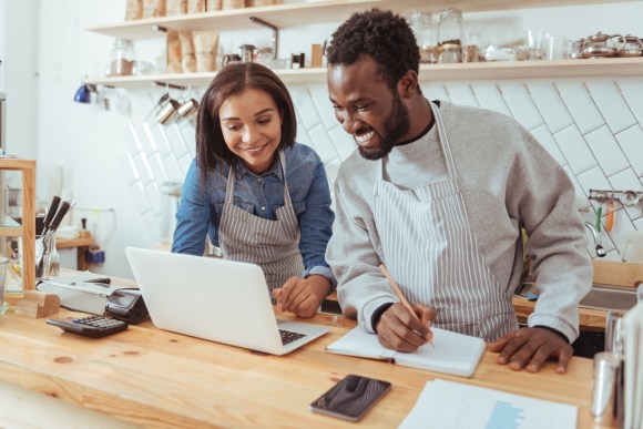 Pleasant young baristas browsing the web and running their own business.