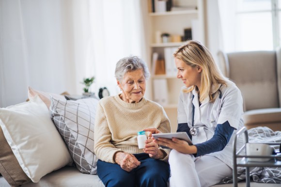 Elderly woman receiving at-home care from a nurse.