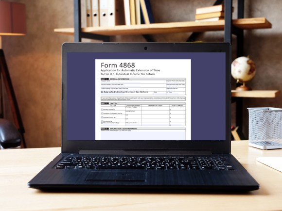 Laptop open with Form 4868 pulled up on the screen.