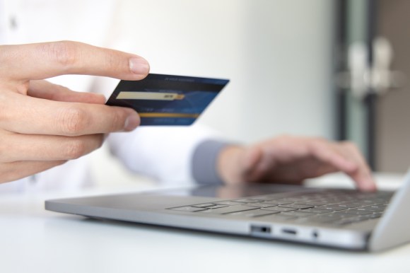 Man making a payment on his laptop using a credit card.
