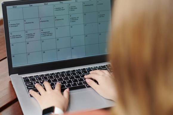 Woman adding to her digital calendar on her laptop.