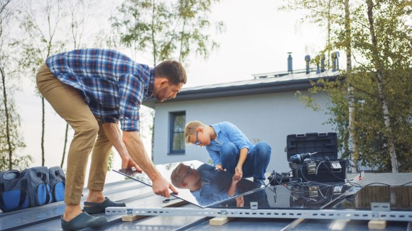 Father and son installing solar panels.