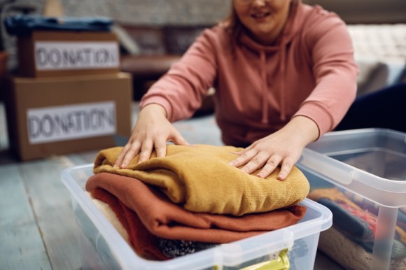 Woman packing clothing for donation.