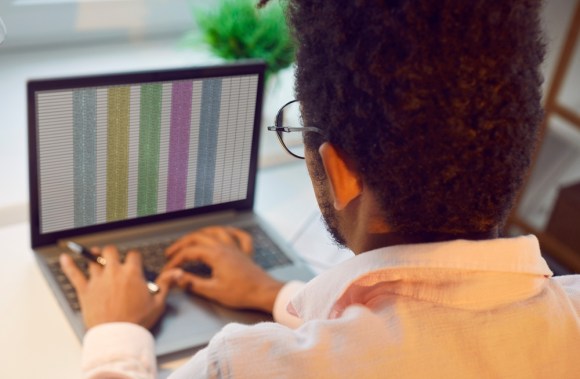 Young man creating a spreadsheet.