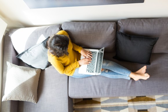 Overhead view of a woman looking something up on her laptop.