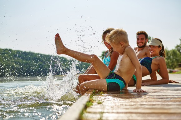 Family sitting on lake dock.