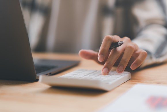 Close-up of man using a calculator.