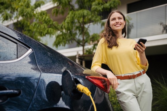 Woman charging electric car.