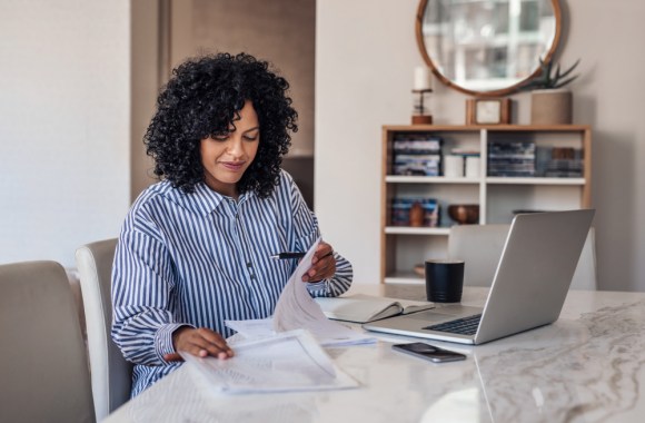 Young Black woman reviewing business paperwork.